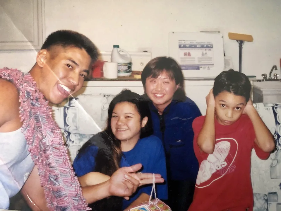 Family in a kitchen wearing lei
